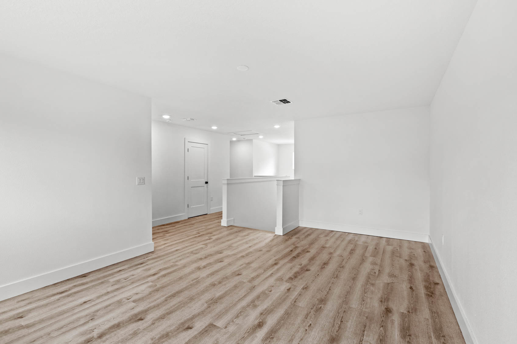 loft with wood floors and hallway to bedrooms